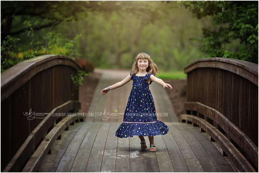 Little girl spinning on bridge in Hershey PA with Family photographer Karissa Zimmer Photography