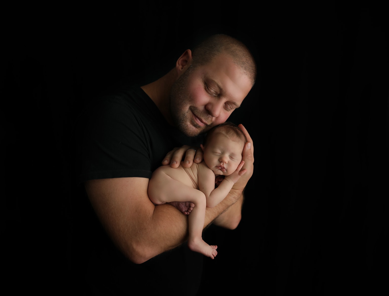 dad poses with newborn baby girl during newborn photography session
