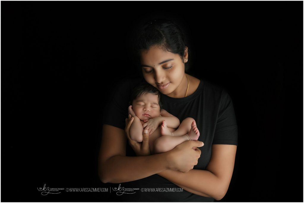 new mom holding newborn baby photographed by karissa zimmer photography