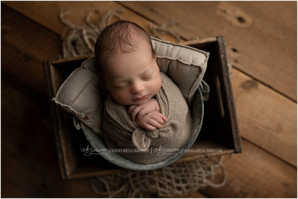 newborn baby boy is posed during his newborn photo session with karissa zimmer photography