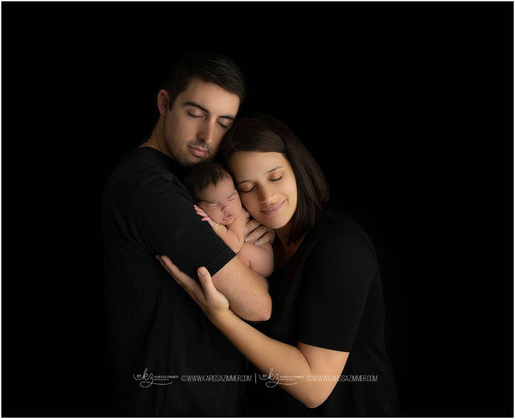 parents pose with their newborn baby at their newborn session