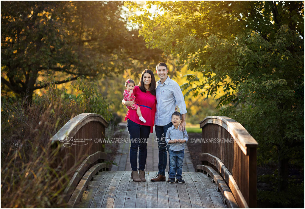 family of 4 poses on bridge in camp hill PA portrait session