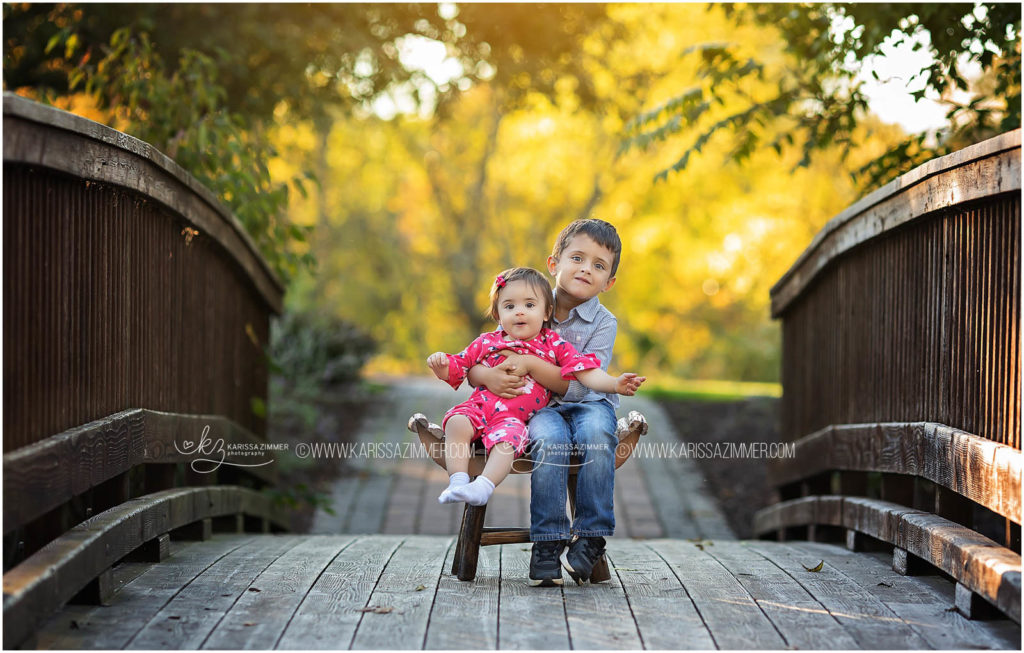 big brother helps hold his little sister at fall family photoshoot with karissa zimmer photography