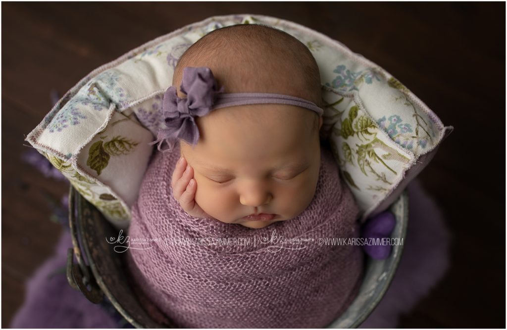 newborn baby girl swaddled in purple and photographed by newborn photographer near 17050