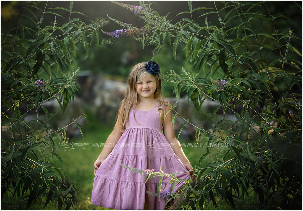 Photographer captures image of little girl wearing purple at her outdoor family photography session