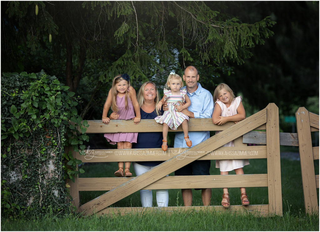 Family poses together along a fence at their family Photography Session at the Peter Allen House