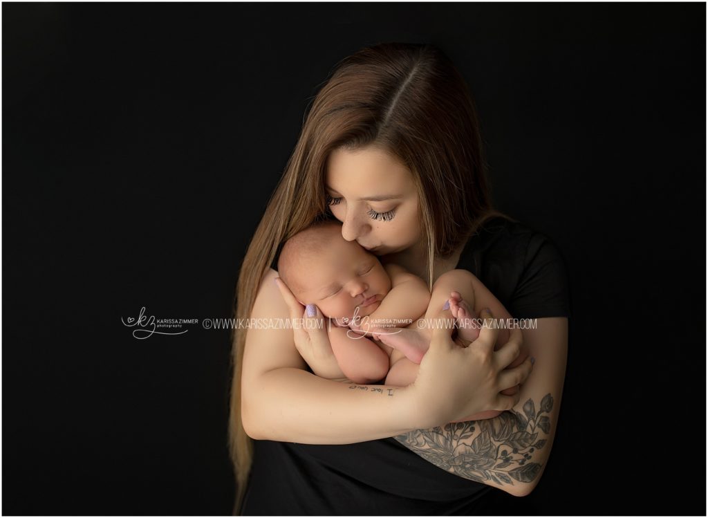 new mother poses with her newborn baby girl at studio newborn photography session near 17050