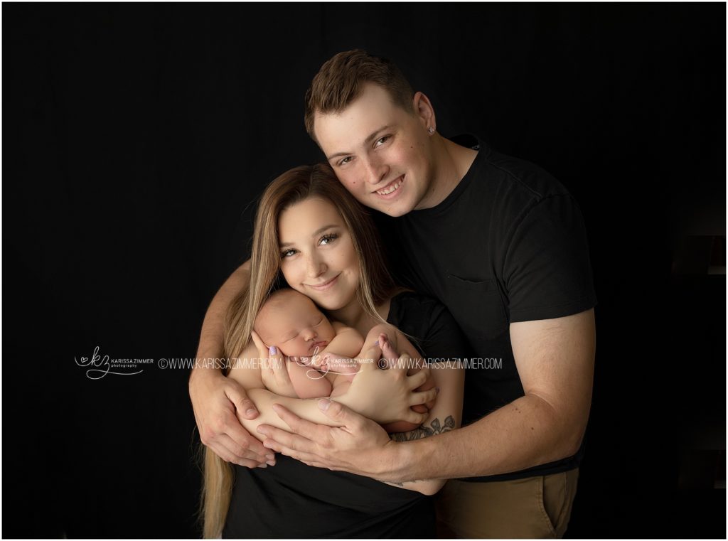 new parents pose with their newborn baby girl during a mechanicsburg pa newborn photography