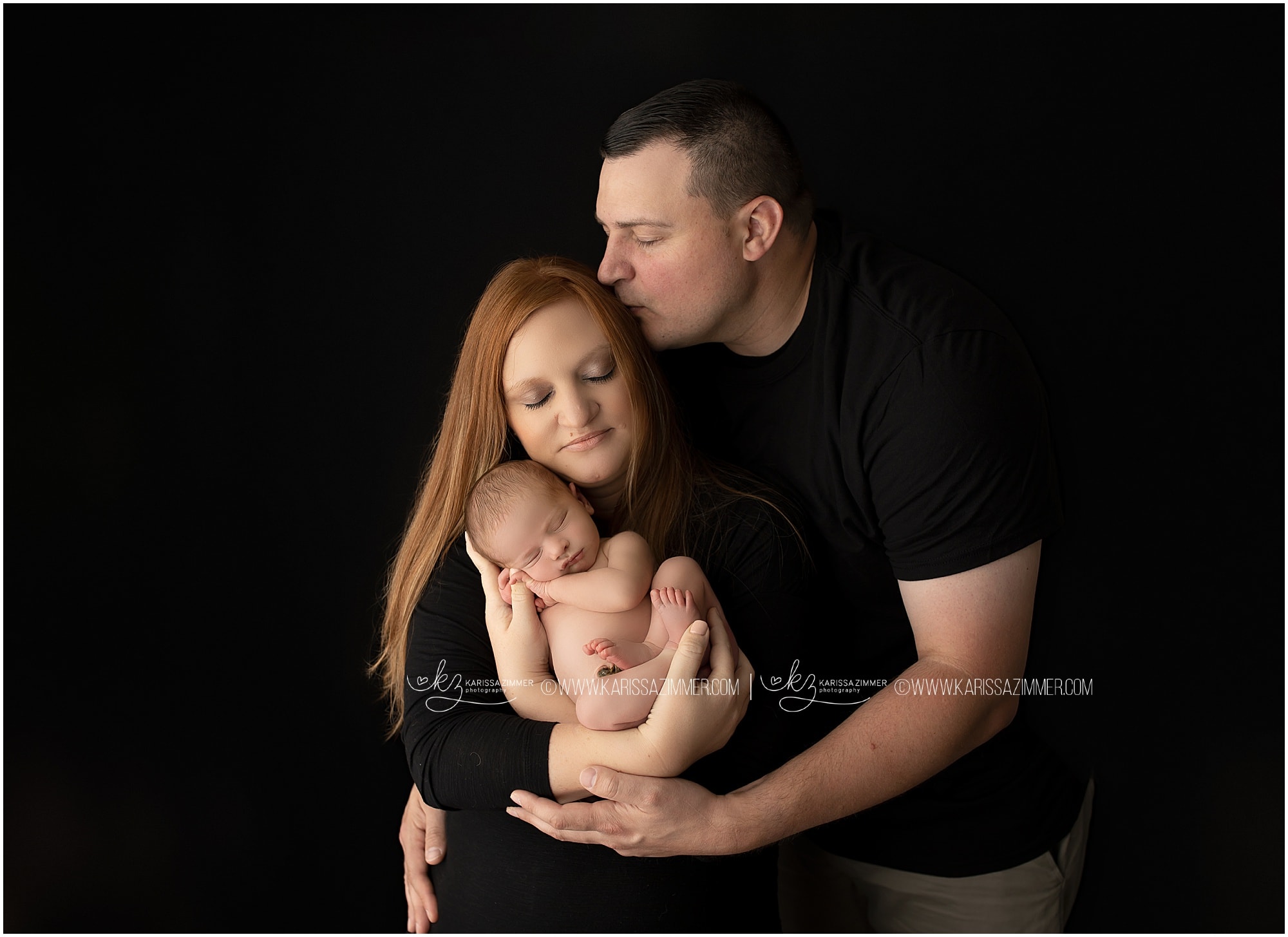 Mother, father, and newborn pose during studio newborn photography session at camp hill PA photo studio