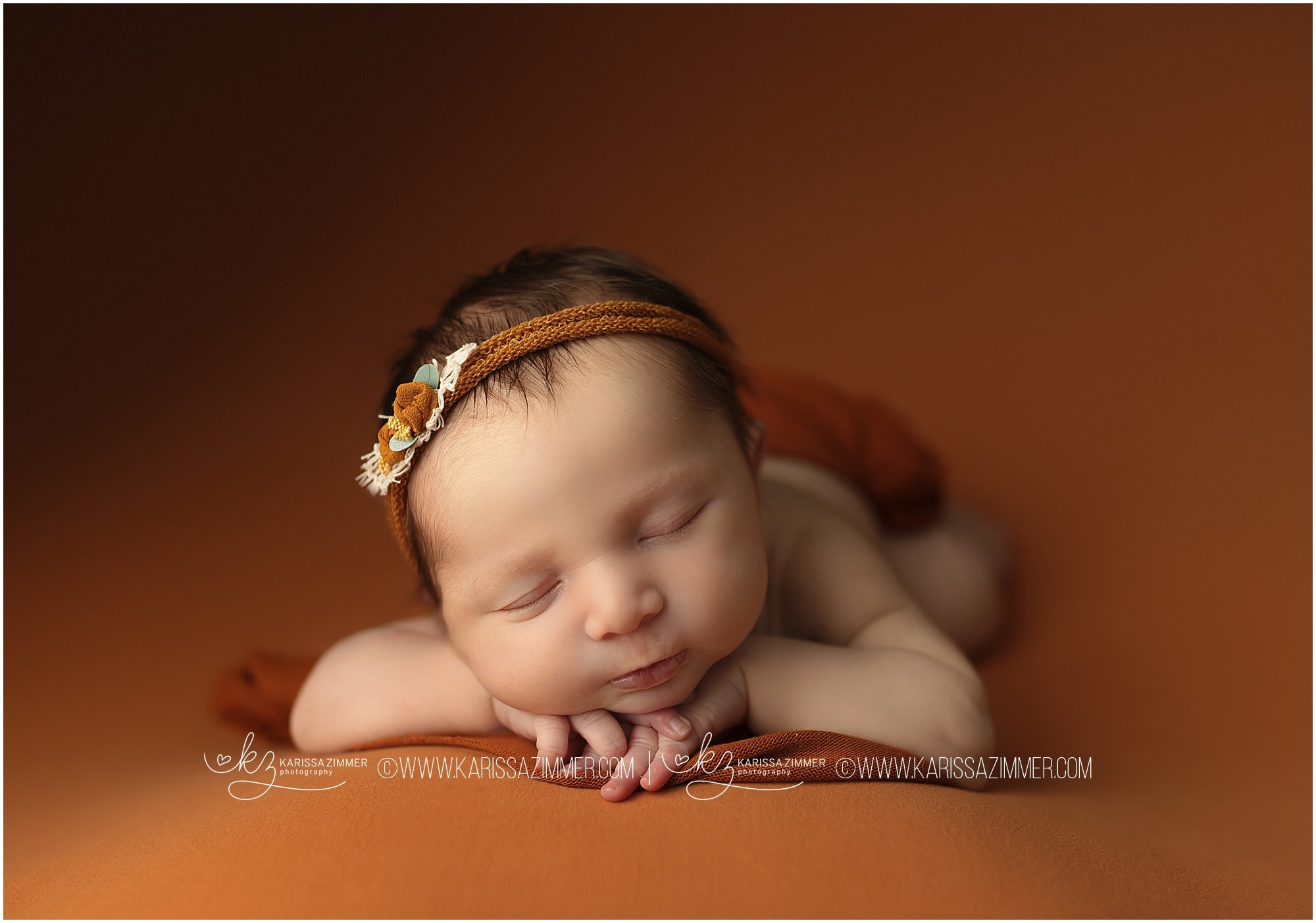 Studio newborn photos on orange backdrop