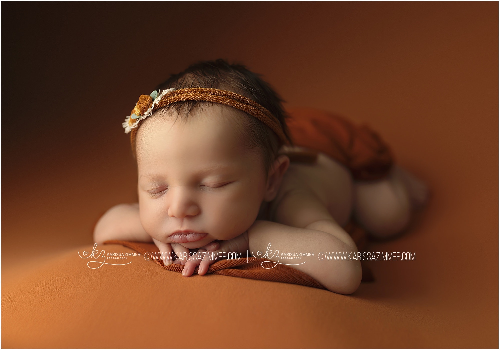 newborn baby girl on orange studio portrait