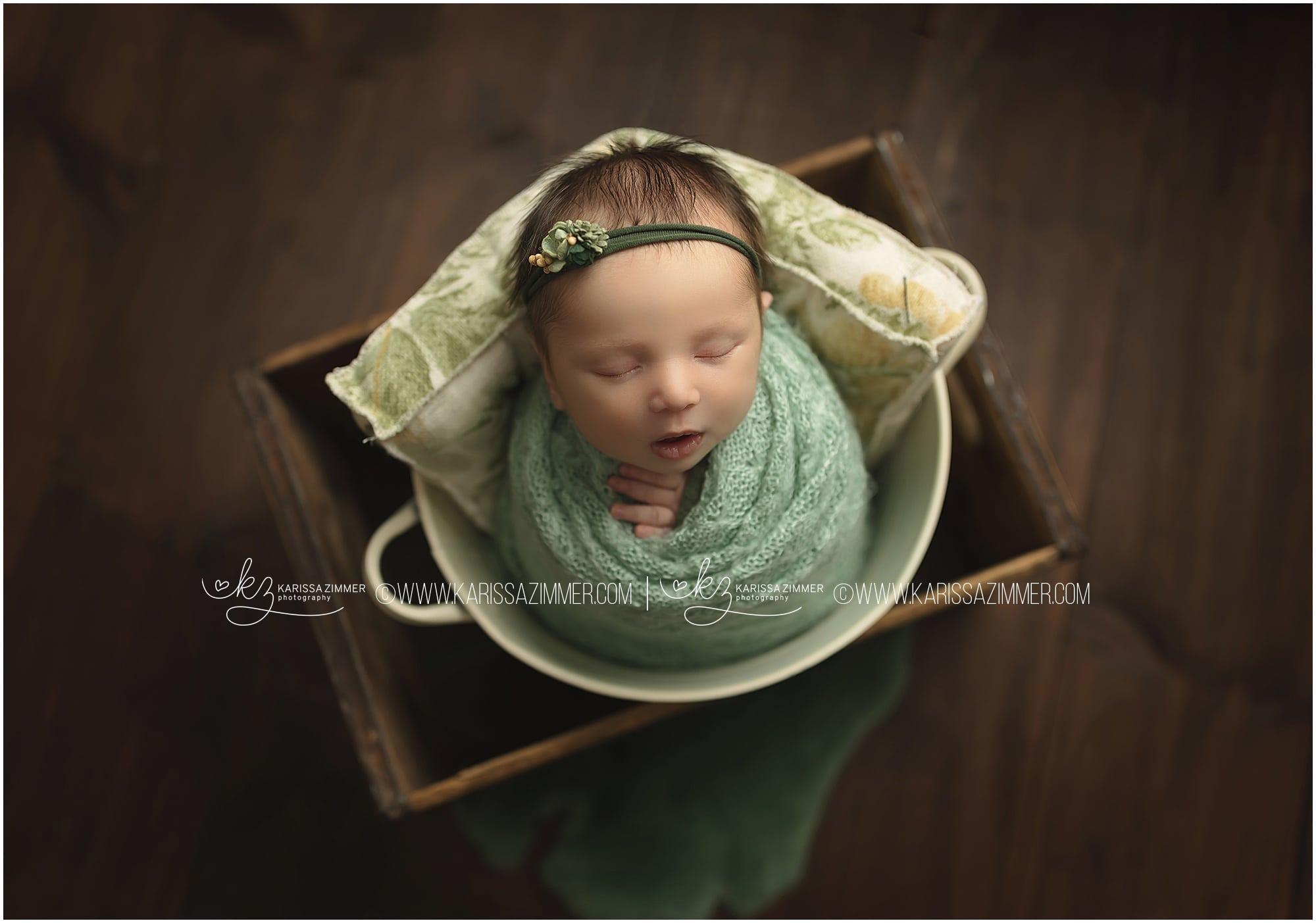 newborn girl wearing green studio photo