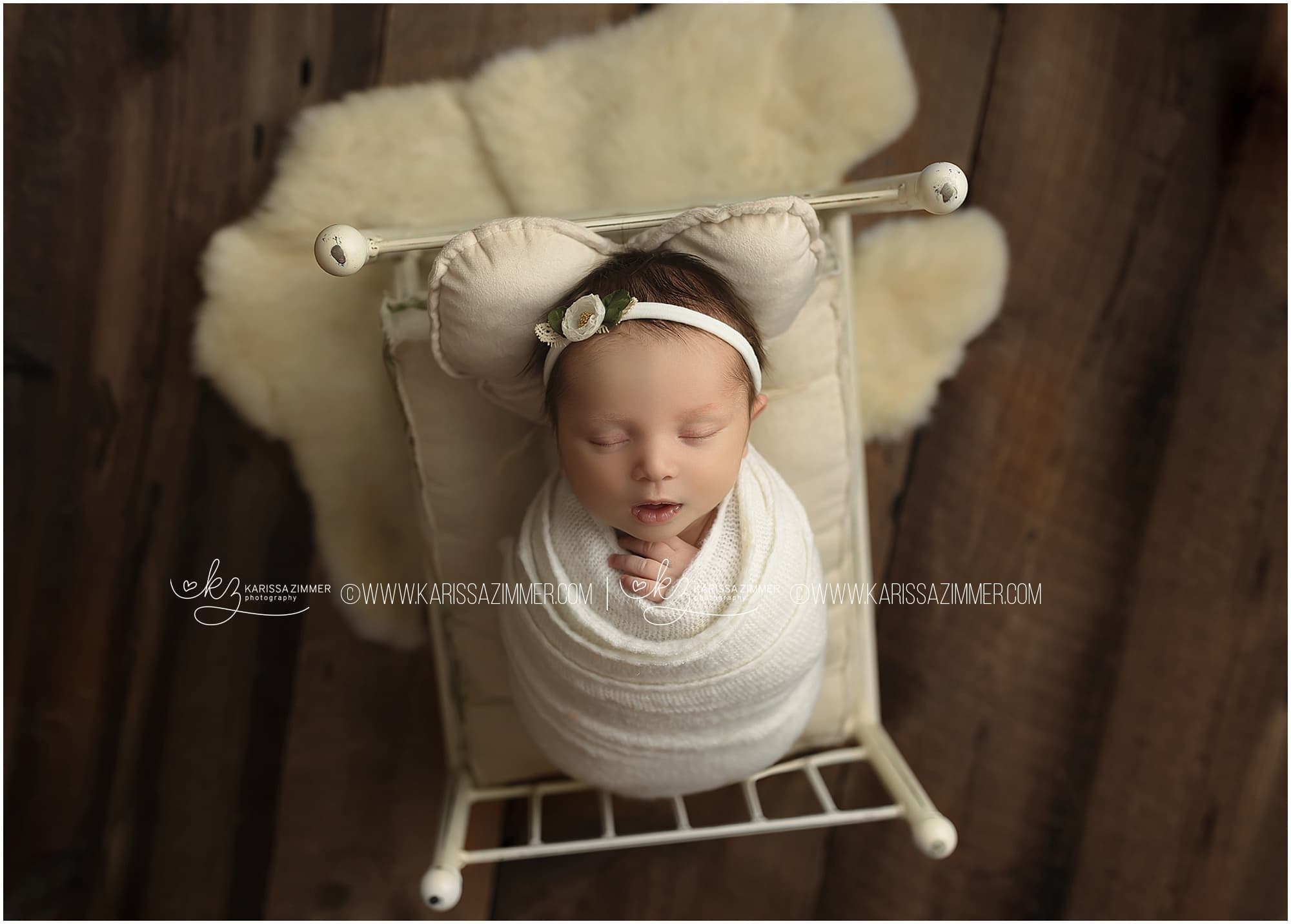 newborn baby on white bed prop studio photo