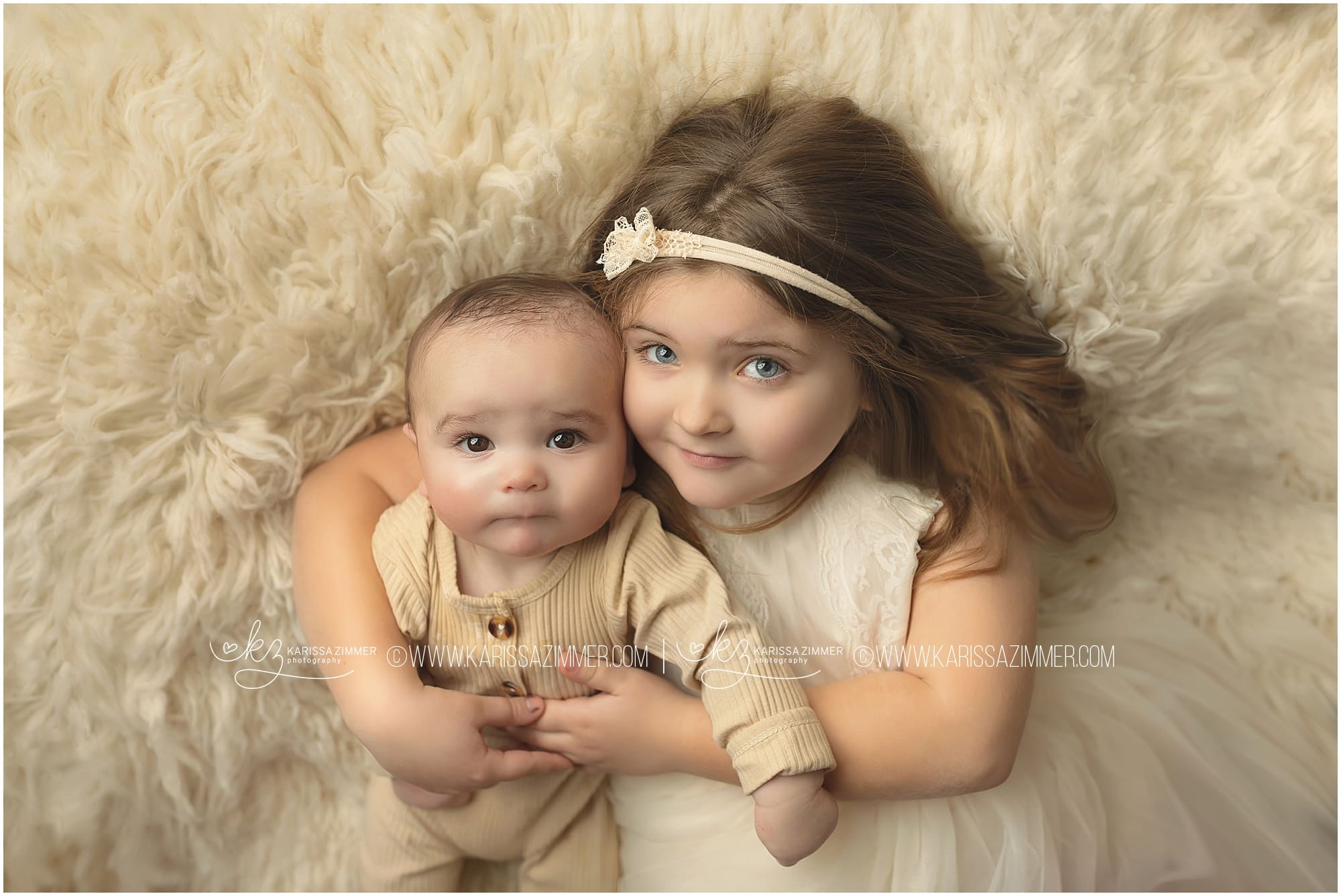 big sister and baby brother on white at studio portrait session