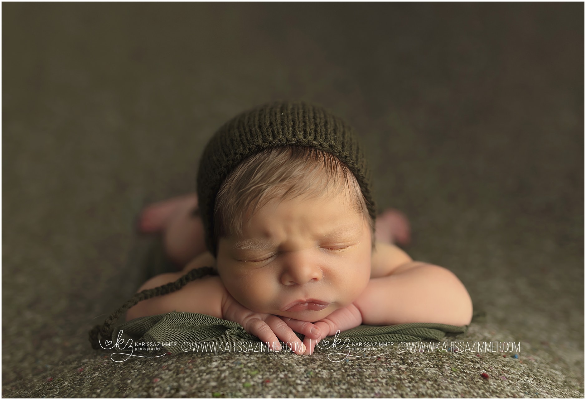 newborn baby boy posed on green backdrop at his Mechanicsburg PA newborn photography session