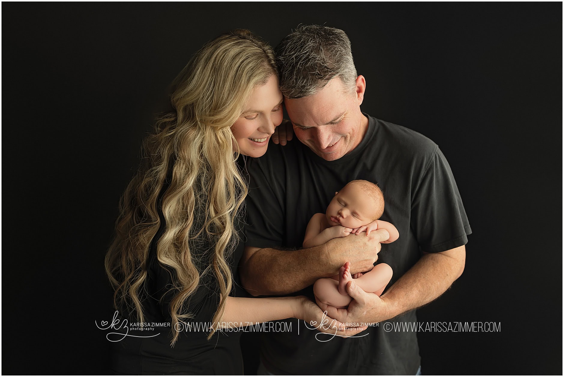 New parents pose with their newborn baby girl in newborn photography studio near Mechanicsburg PA