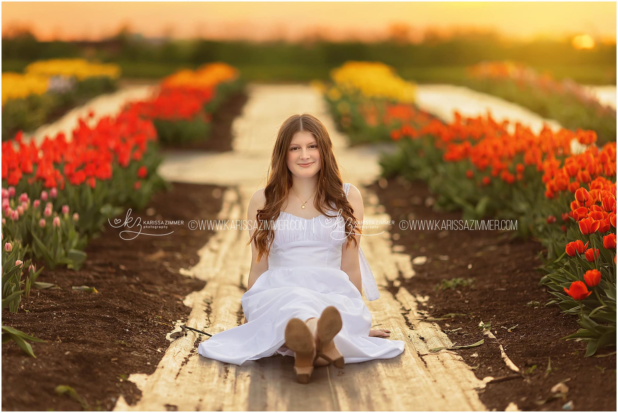 A Central Dauphin high school senior sits in a beautiful field of tulips at her Harrisburg PA senior photo session with Karissa Zimmer Photography. 