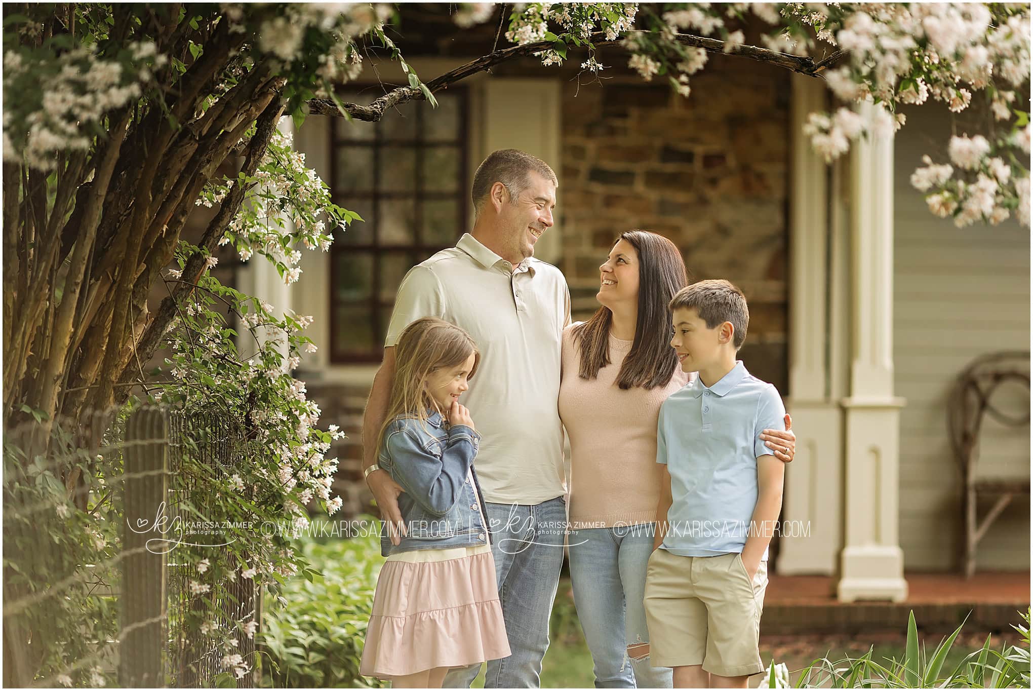 A mother, father and 2 young children embrace one another during their family portrait session