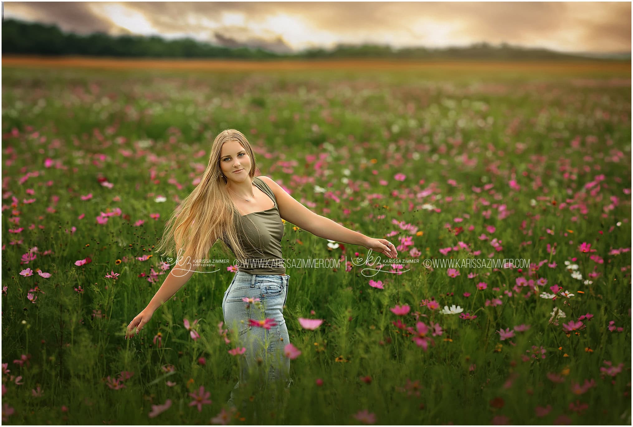 A high school senior girl dances through a wildflower meadow at her outdoor photoshoot with best Mechanicsburg PA Senior Photographer