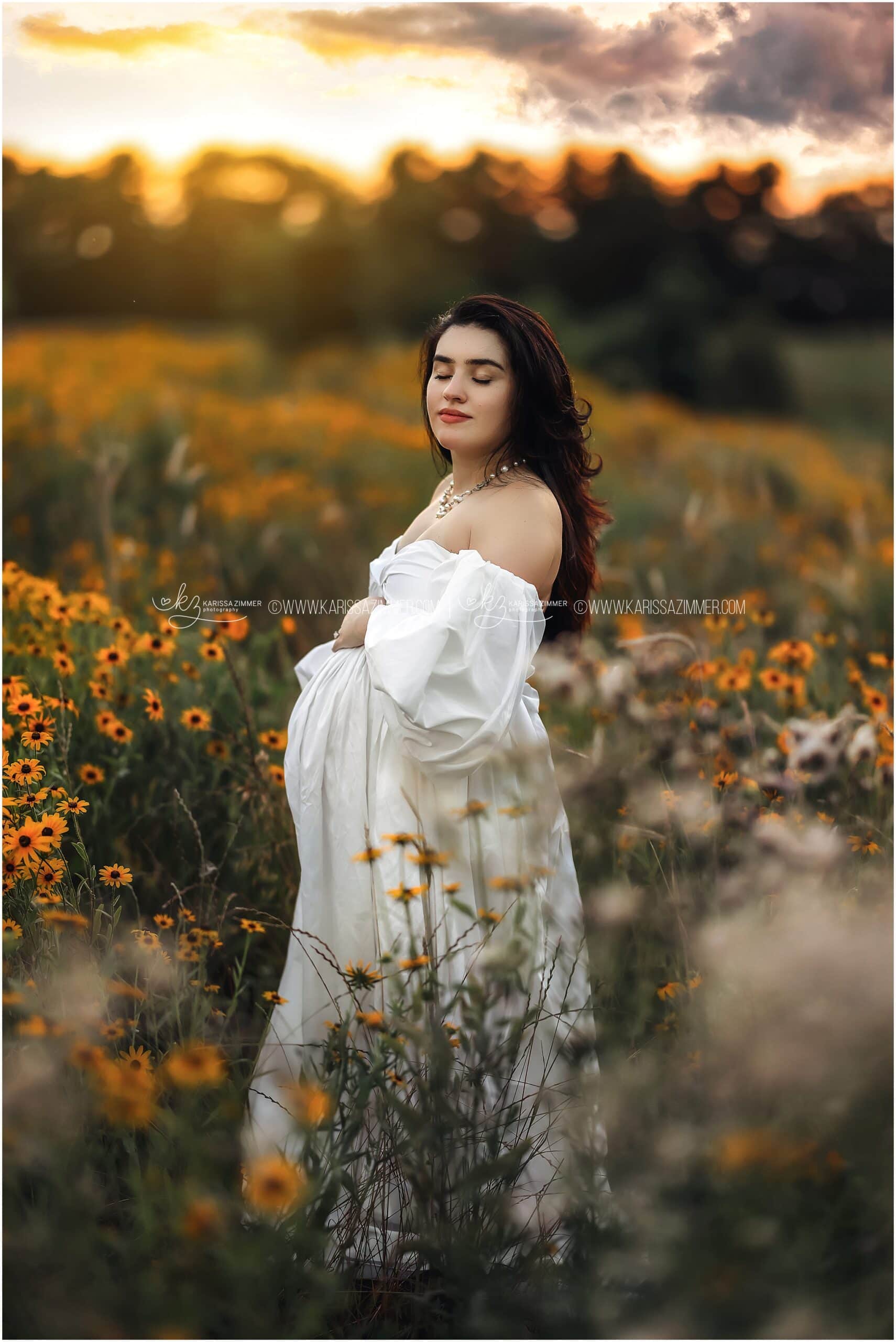 A mom-to-be poses in a beautiful, yellow flower field at sunset at her Hershey PA Maternity Photo session with Karissa Zimmer Photography