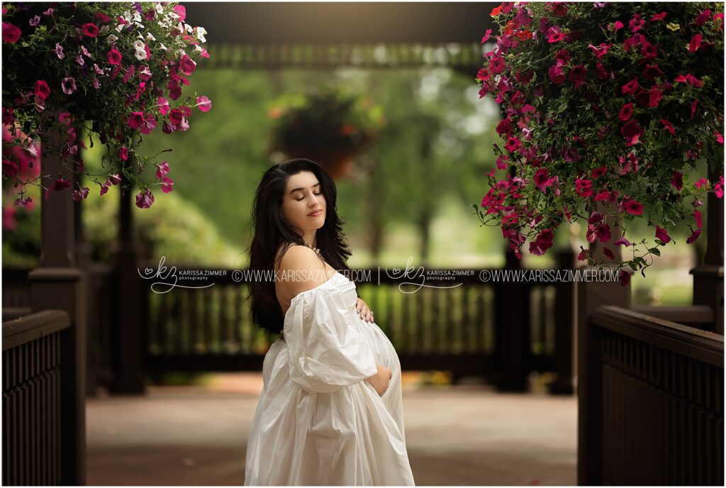 A beautiful expecting mother closes her eyes as she holds her belly at her outdoor maternity photography session in Central PA