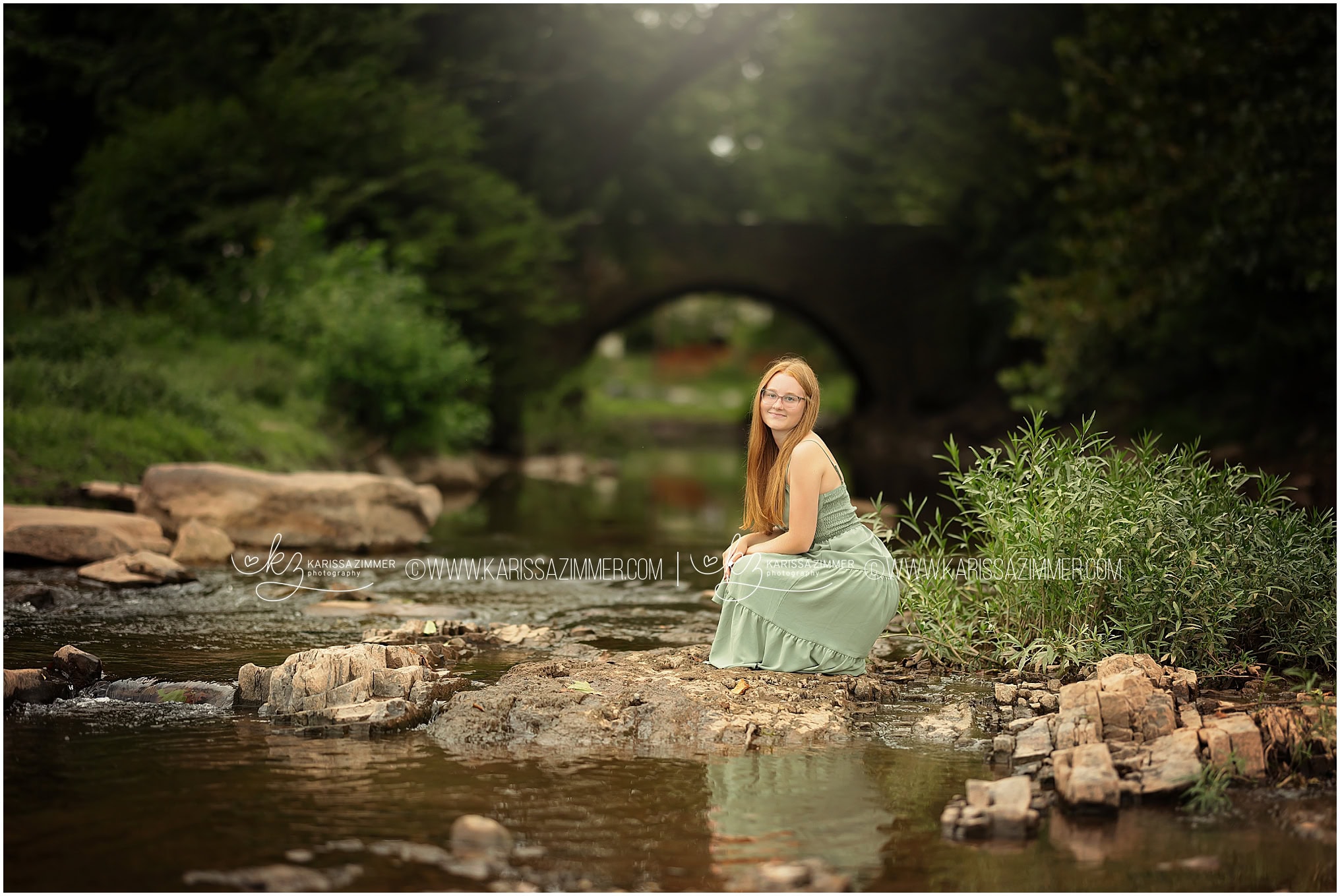 High School girl poses on a rock in the river during her senior pictures with Karissa Zimmer Photography