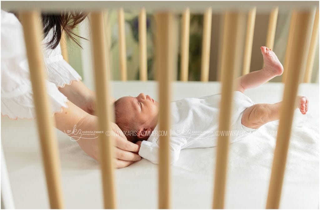 Mechanicsburg Lifestyle newborn photographer captures candid image of a newborn baby girl laying in her crib.
