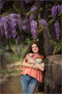High School senior girl poses with her childhood stuffed animals